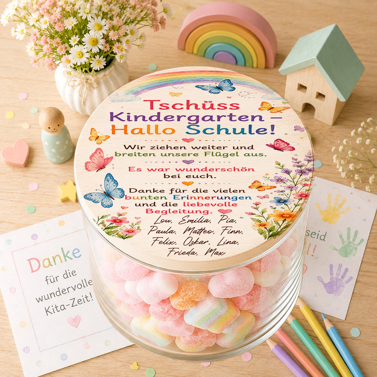 Personalisiertes Bonbonglas zum Kita Abschied mit Schmetterlingen und dem Spruch „Tschüss Kindergarten – Hallo Schule“ sowie den Namen aller Kinder als individuelles Gruppengeschenk für Erzieherinnen