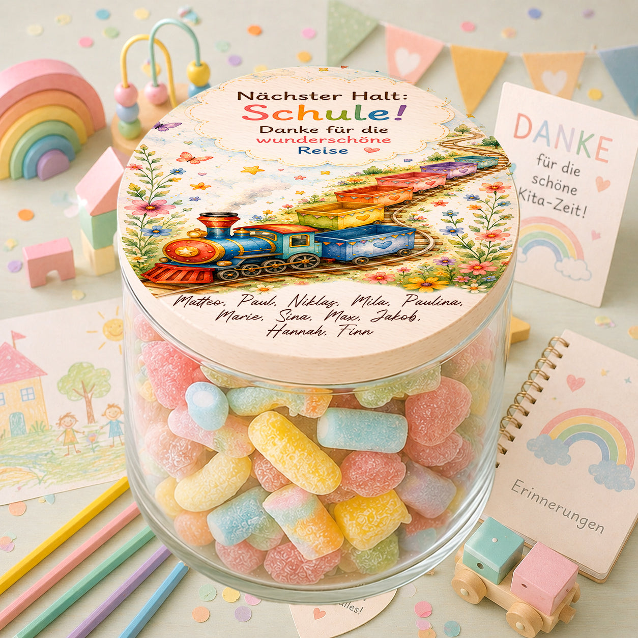 Personalisiertes Bonbonglas mit buntem Zugmotiv, Kindernamen und Spruch „Nächster Halt Schule“ als Abschiedsgeschenk für Erzieherinnen und Erzieher im Kindergarten