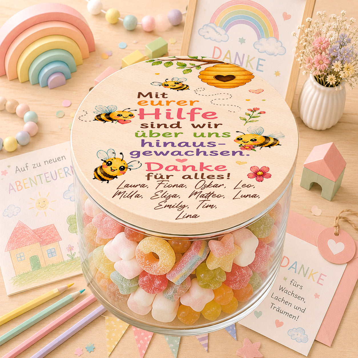 Personalisiertes Bonbonglas als Kita Abschiedsgeschenk mit Bienenmotiv, Blumen und dem Spruch „Mit eurer Hilfe sind wir über uns hinausgewachsen. Danke für alles!“ sowie den Namen aller Kinder