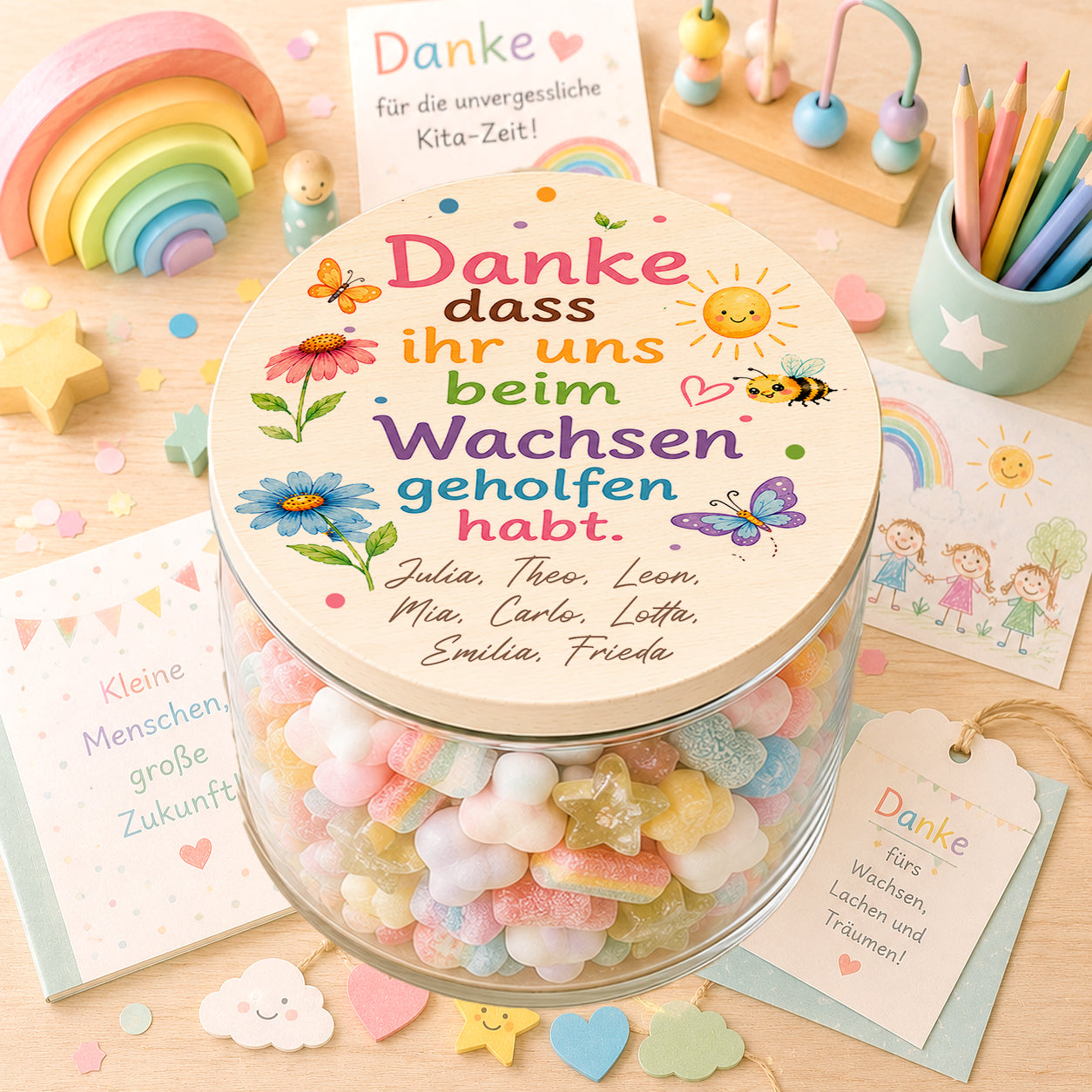 Personalisiertes Bonbonglas als Kita Abschiedsgeschenk mit bunten Blumen, Schmetterlingen, Bienen und dem Spruch „Danke, dass ihr uns beim Wachsen geholfen habt“ sowie den Namen aller Kindergartenkinder
