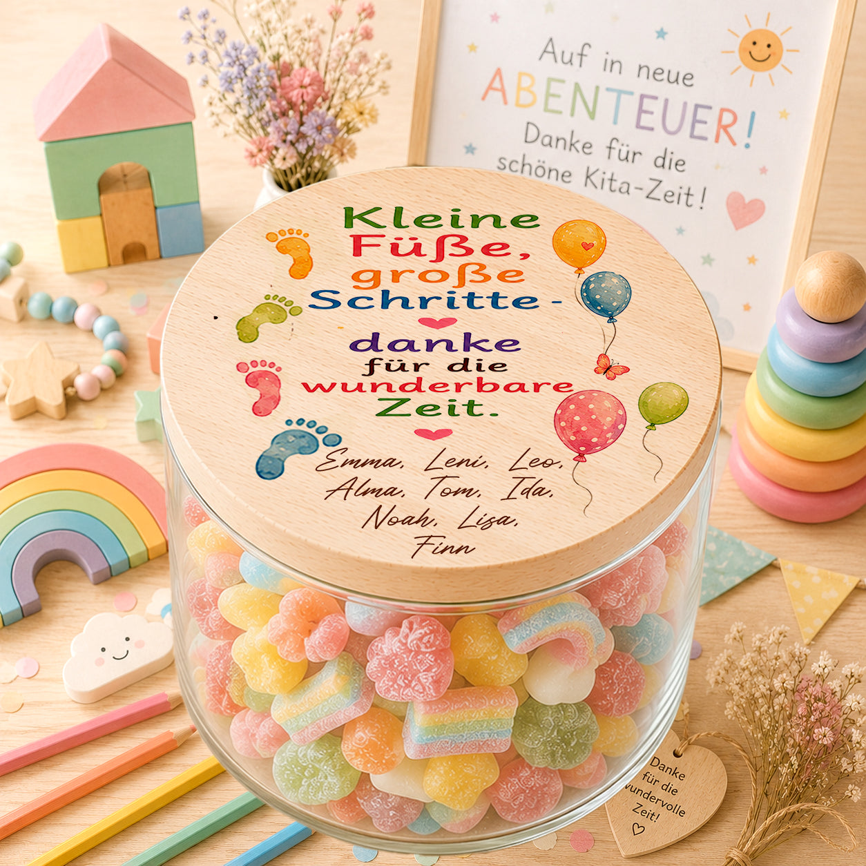 Personalisiertes Bonbonglas mit bunten Fußspuren, Kindernamen und der Aufschrift „Kleine Füße, große Schritte“ als Kita Abschiedsgeschenk für Erzieherinnen